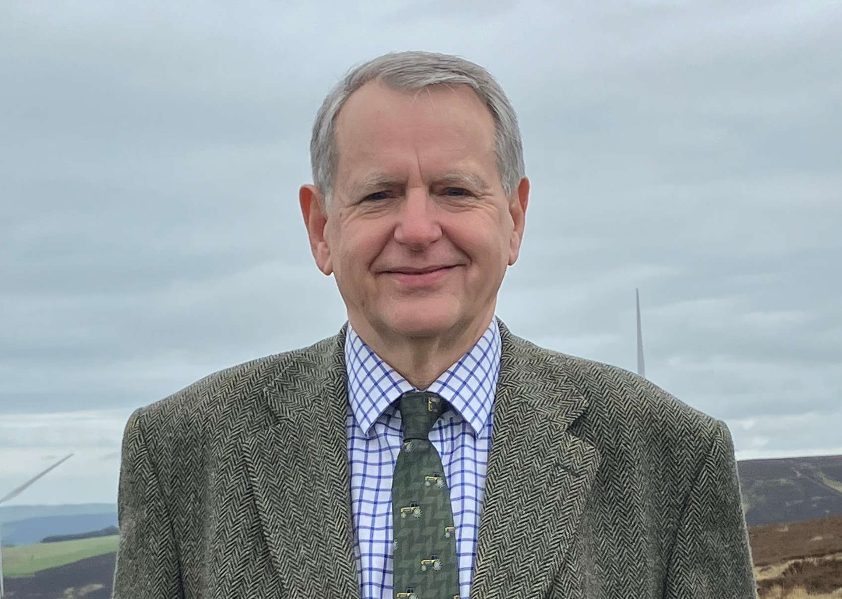 Brian Richardson standing in a field of sheep